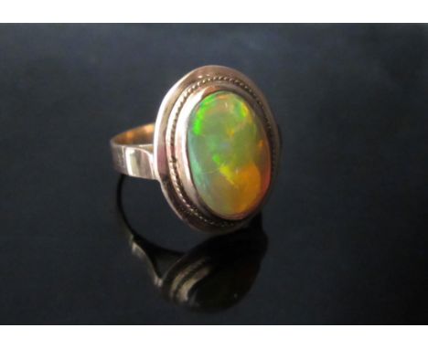 A gold ring set with an oval cabochon yellow opal (shank replaced) unmarked. Size O, 3.6g 