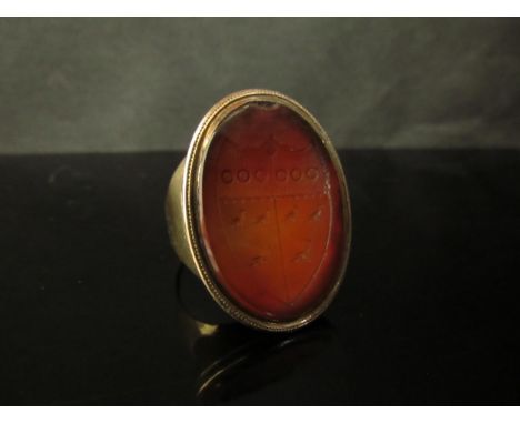 A Victorian gold ring with large Cornelian carved intaglio of a shield, unmarked. Size S, 13.1g 