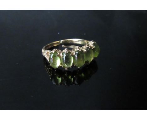 A 9ct gold ring set with five cabochon peridots. Size O/P, 2.7g 