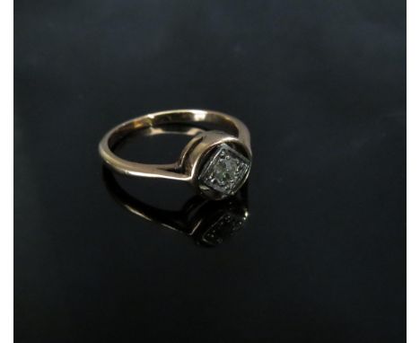 An unmarked rose gold ring with a single diamond in a square setting set within a halo, 0.10ct approx. Size M, 1.9g 