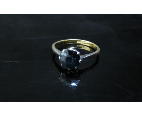 A gold ring with a circular sapphire, stamped 18ct, surface of stone worn. Size M, 2.4g 