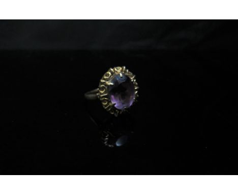 A 9ct gold ring set with an oval amethyst in a fancy mount. Size R, 3.9g 