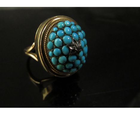 A gold ring with removable domed turquoise front centrally set with a small diamond in star setting revealing a vacant interi