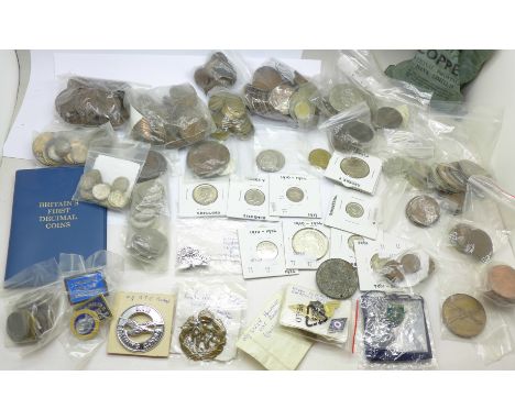 A collection of coins including copper and silver, and enamel and other badges