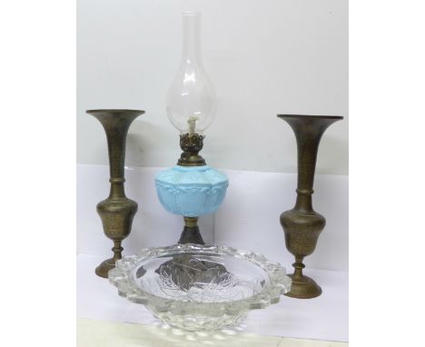 An oil lamp with cast metal base and blue glass reservoir, a pair of Indian brass vases and a glass light shade
