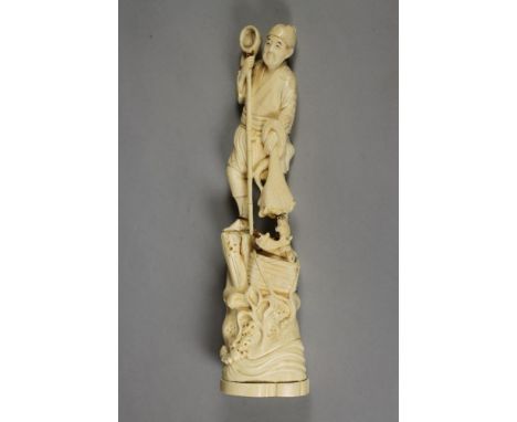 A JAPANESE ONE PIECE IVORY OKIMONO, Meiji period, of a fisherman holding a long net/spear in his right handle and another net