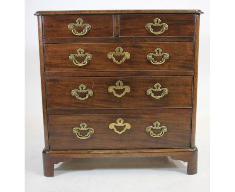 A SMALL GEORGIAN MAHOGANY CHEST, late 18th century, of rounded oblong form, the moulded edged top banded and quarter veneered