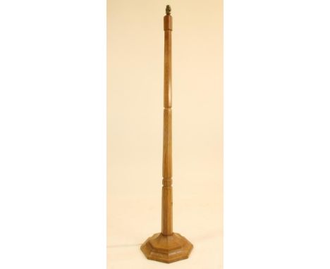 A MALCOLM PIPES OAK STANDARD LAMP, the faceted tapering stem with moulded collar, raised on moulded stepped octagonal base, c