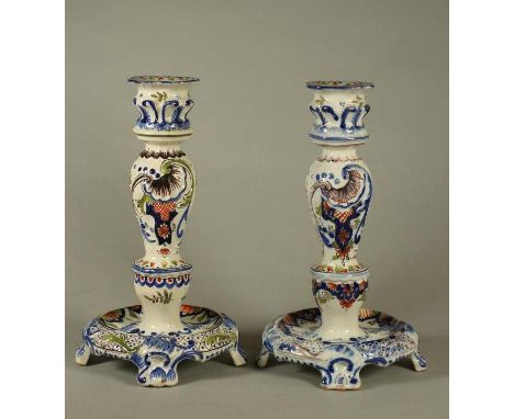 A COMPOSITE PAIR OF FRENCH FAIENCE CANDLESTICKS, late 19th century and later, fixed quatrefoil drip pans on lobed sockets, th
