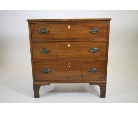 A GEORGIAN MAHOGANY CHEST, early 19th century, the banded and string inlaid top over three long drawers with oval brass drop 