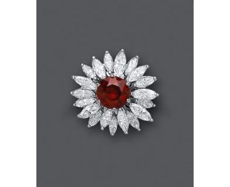 A GARNET AND DIAMOND COCKTAIL RING, the central circular facet cut garnet claw set to a sunburst of nineteen marquise cut dia