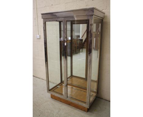 AN ART DECO OAK DISPLAY CABINET of oblong form with two doors having ring handles, the interior with mirrored back glass, gla