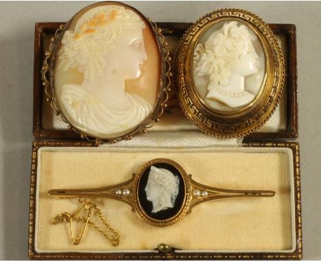 A VICTORIAN 15CT GOLD PROPELLOR BROOCH centred by an oval sardonyx plaque carved in high relief with a female head portrait i