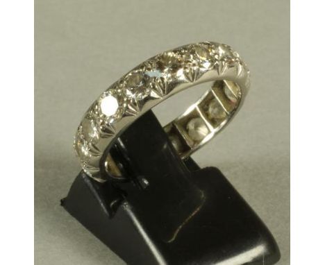 A DIAMOND ETERNITY RING, the wide white metal band pave set with seventeen brilliant cut stones each of approximately 0.20cts