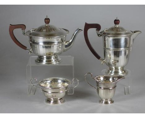 A FOUR PIECE SILVER TEA AND COFFEE SERVICE, makers Ogdens, Birmingham 1933, of semi fluted rounded cylindrical form comprisin