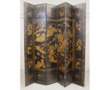 A CHINESE BLACK LACQUERED SIX FOLD SCREEN, 19th century, of oblong form painted and gilded to one side with figures in a gard