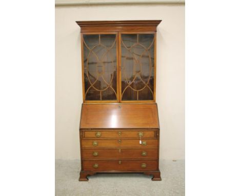 A GEORGE III MAHOGANY BUREAU BOOKCASE, c.1800, the moulded and dentil inlaid cornice over two astragal glazed doors in an ova