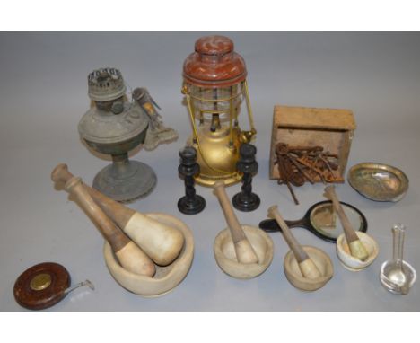 An interesting mixed lot of collectables including a Tilley Lamp, keys, ebonised candlesticks graduated stone pestle and mort