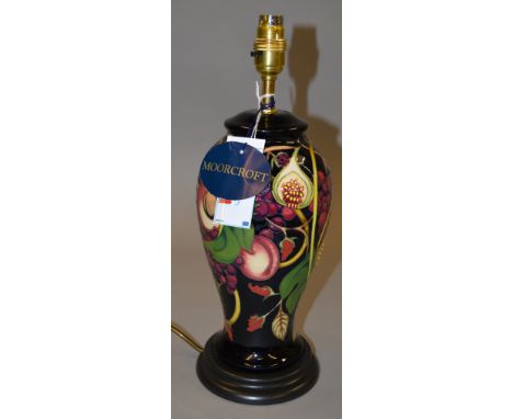 A Moorcroft lamp base decorated with grapes, peaches and figs. 38cm tall.