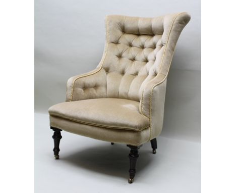 AN EDWARDIAN DRAWING ROOM BUTTON BACK EASY CHAIR, upholstered in cream fabric, the high button back fans out into semi-wings,
