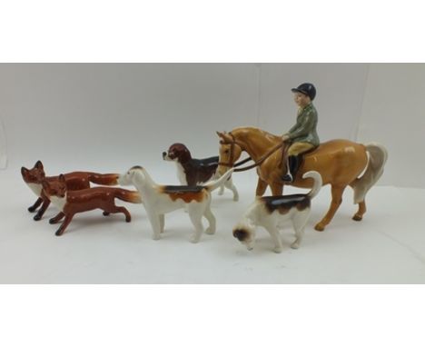 A BESWICK CERAMIC FIGURE, a boy wearing a green hacking jacket riding a Palomino pony, together with three hounds and two fox