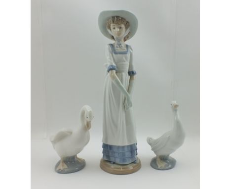 TWO NAO DUCKS together with a NAO FIGURINE of a lady wearing a long dress, broad brimmed hat and long gloves, 32cm high (3) 