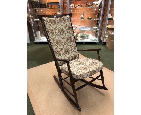 A 20th C. STAINED WOOD ROCKING ARMCHAIR WITH CUSHIONED STICK BACK AND DROP IN SEAT.