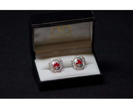 A pair of silver gaming cufflinks decorated with enamel hearts.