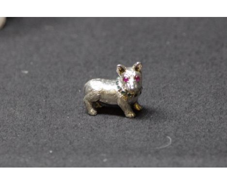 A cast silver model of a corgi dog set with ruby eyes.