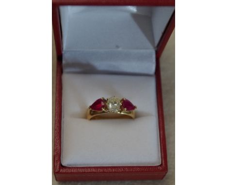 A platinum and 22ct gold three stone diamond and ruby dress ring, the central oval shaped diamond flanked by two pear shaped 