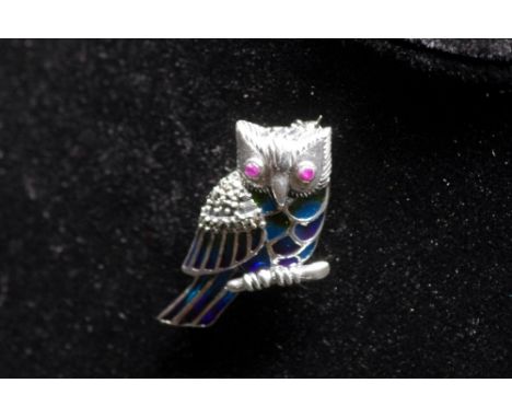 A silver and Plique A Jour brooch in the form of an owl inset with marcasite and ruby eyes.