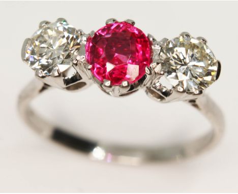 A three stone diamond and ruby ring, the central oval cut ruby approx. 0.93 carats, total approx. diamond wt. 1.16 carats, wh