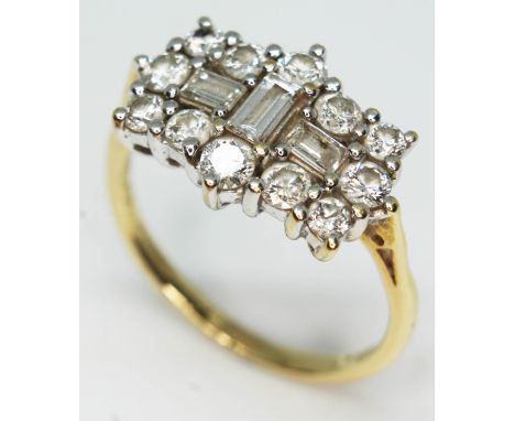 A diamond cluster ring featuring three central baguette cut diamonds surrounded by 12 round brilliant diamonds, gross approx.