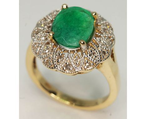 An emerald and diamond ring, the central oval cut emerald approx. 2.14ct, band marked '14K', gross wt. 7.3g, size S.  