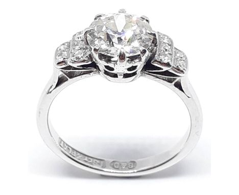 A diamond solitaire ring by Boodle and Dunthorne, the central diamond approx. 1.40 carats, diamond set shoulders, the 18ct wh