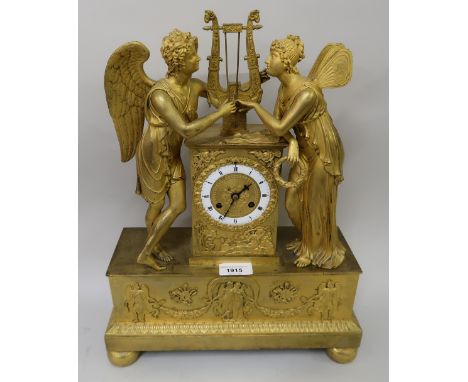 Early 19th Century French ormolu mantel clock, the circular enamel dial flanked by two figures of angels, the dial inscribed 