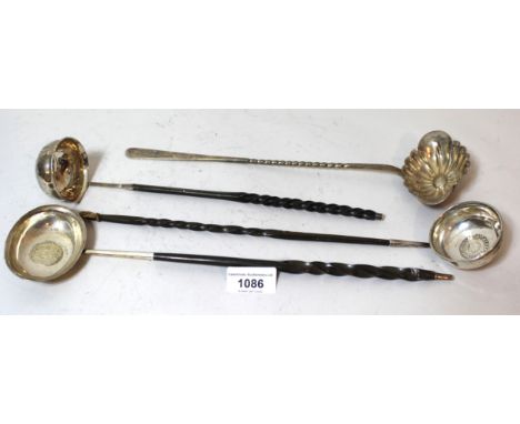 Three antique white metal toddy ladles, with coin inset bowls and turned whalebone handles, together with a Continental white