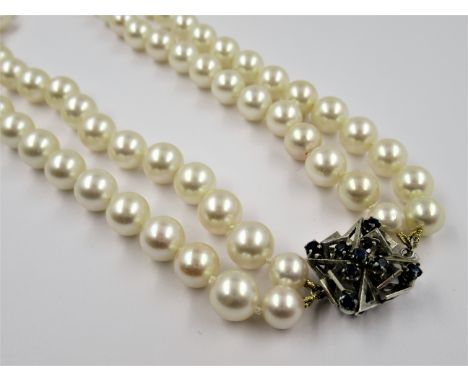 Double row uniform cultured pearl necklace with 14ct white gold and sapphire set clasp, the pearls each approximately 8mm dia