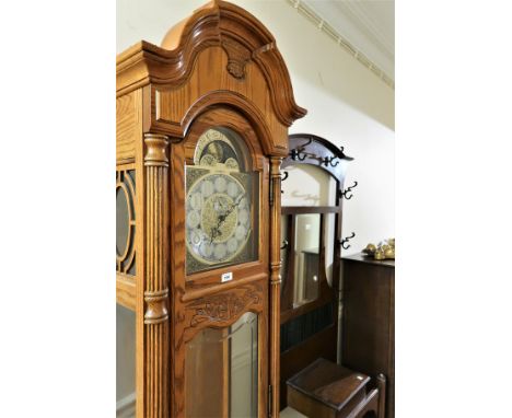 Modern reproduction light oak longcase clock with moonphase dial, signed Howard Miller, the three train weight driven movemen
