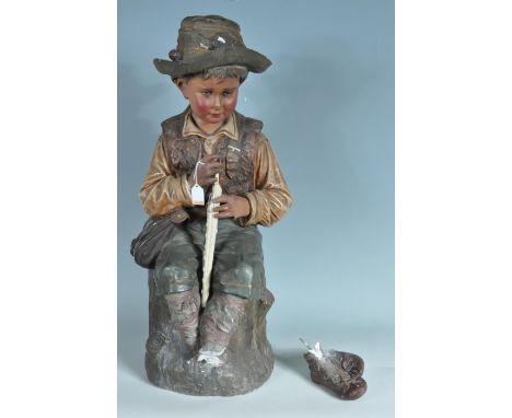 An antique 20th Century continental painted plaster figure / statue in the form of a young young boy seated upon a tree stump