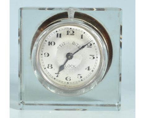 A retro vintage 1960s Tit Bits travelling alarm clock having a circular clock face with arabic numerals to the chapter ring. 