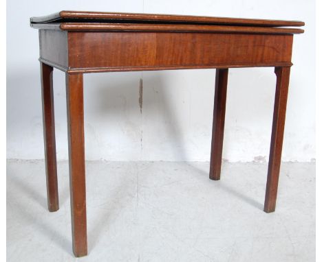 An antique 19th century Georgian mahogany card / games table having a flip top opening to reveal a green baize laying surface