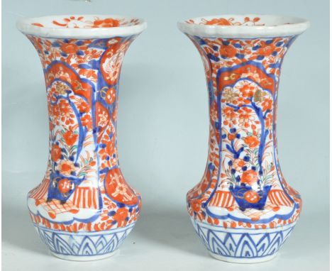 A pair of antique early 20th century Meji period Japanese Imari vases having an everted rim and shallow-reeded body which is 