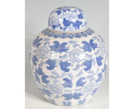 A large Chinese 20th century ceramic blue and white lidded ginger jar of ovoid form having floral decoration throughout. Smal