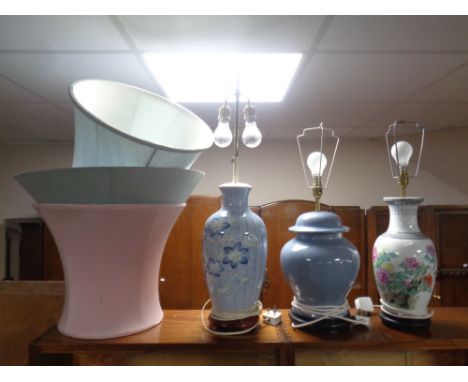 A ceramic Japanese style table lamp on wooden base together with two further ceramic table lamps, all with shades.