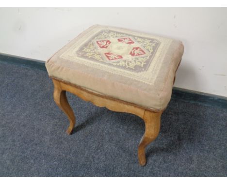 An antique walnut dressing table stool with tapestry seat 