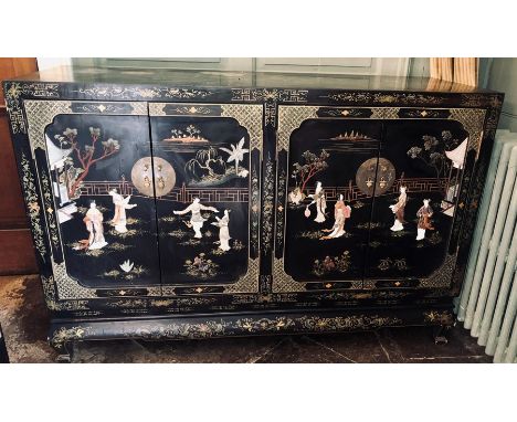 A Chinoiserie lacquered sideboard, rectangular top above two sets of two panelled cupboards with brass handles, revealing mat