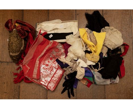 A collection of vintage gloves, crochet and lace and scarves with fringing. A brightly striped silk runner, a 1930s under-sli