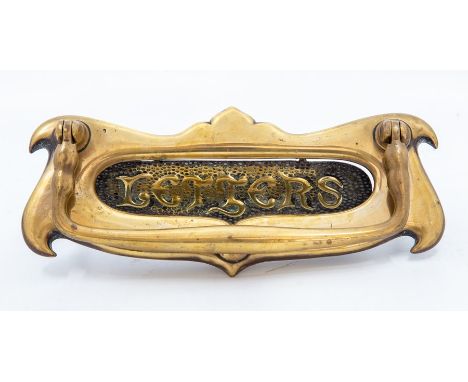 An Edwardian art nouveau brass door letter plate, circa 1900-1910, of double-scroll form, with shaped swing knocker handle, t