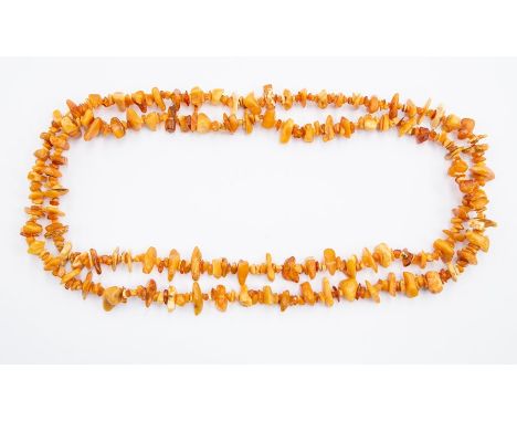 A single row Amber necklace, the rough polished long necklace comprising butterscotch and various amber tone irregular beads,